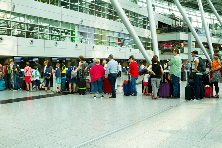 Düsseldorf, Germany - July 22, 2016: Capture of long queue of people and passengers at check-in of Finnair in hall of airport Düsseldorf in summer holiday season.