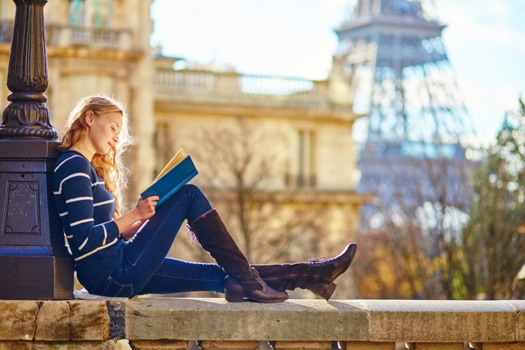 Beautiful young woman in Paris, reading a book