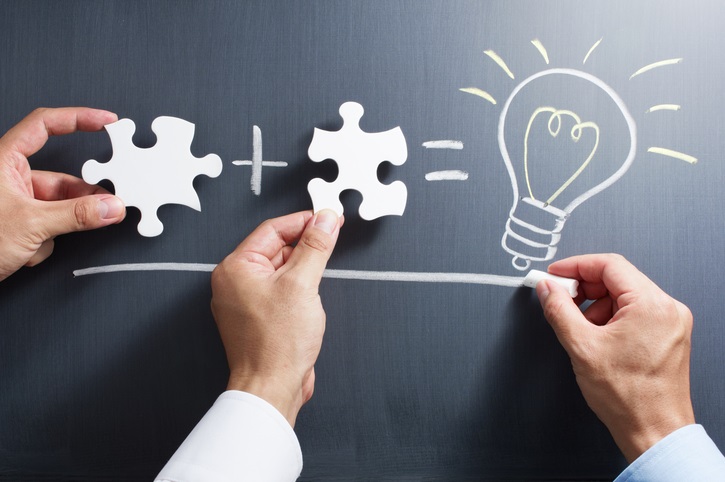 Solving puzzle together. Drawing light bulb on blackboard.